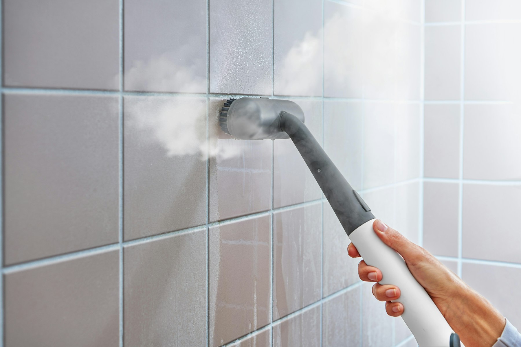 Steam cleaner sanitising washroom tiles